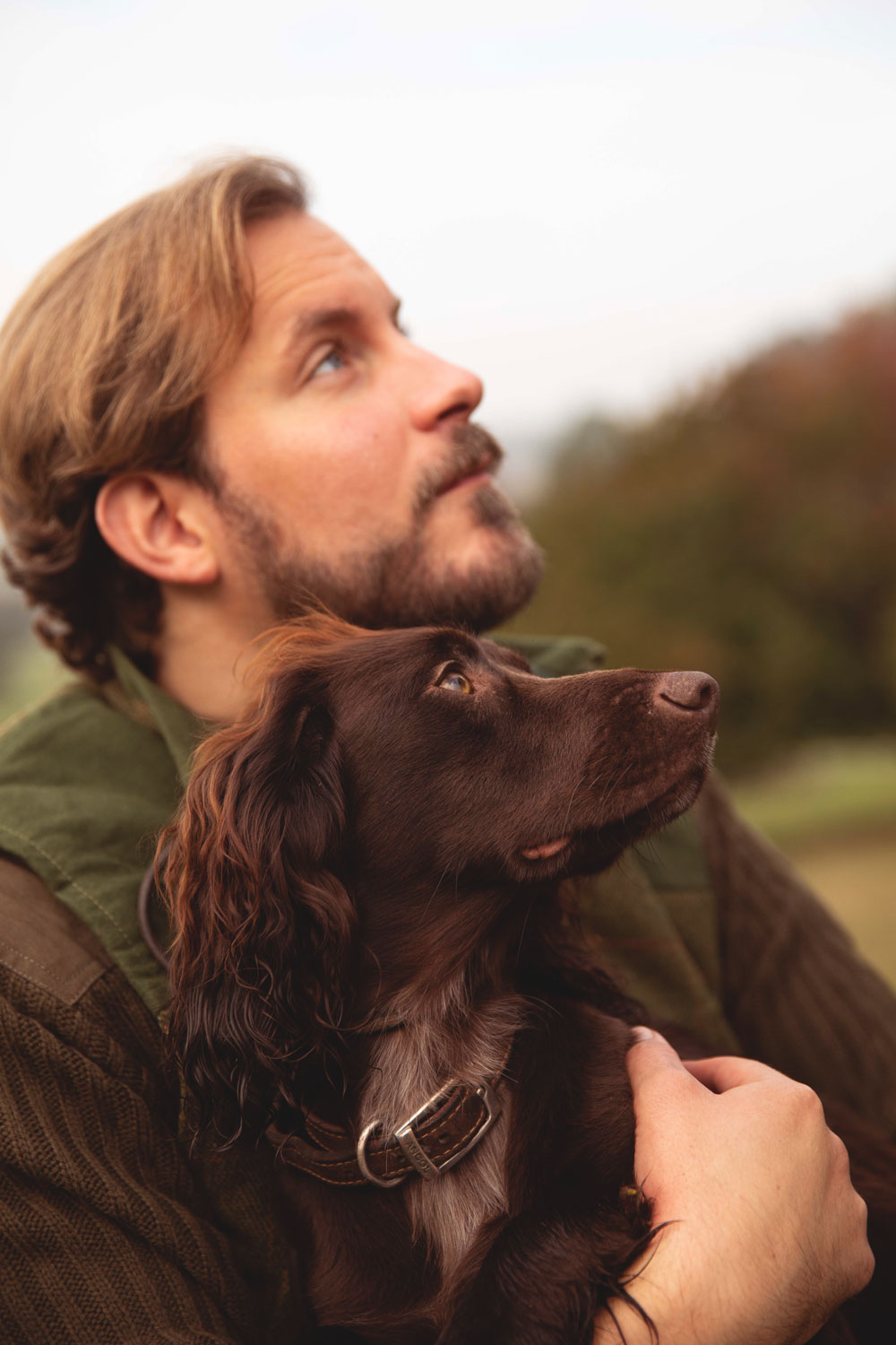 Man hugging his dog in the wind